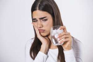Woman drinking ice water has teeth sensitivity in scranton pa