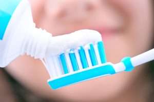 image of toothpaste being added to a toothbrush - what happens if you don't brush your teeth? Learn with Abington Center for Cosmetic & Family Dentistry, a dental practice located in Clarks Summit, PA.